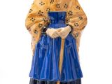 figurine représentant une femme vêtue d'une robe bleue, coiffée d'un chapeau et tenant une canne