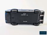 a black and blue camera sitting on top of a white table