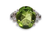 gros plan d'une bague avec une pierre verte entourée de diamants