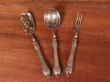 three spoons and a fork on a wooden table