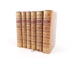 three books are stacked on top of each other on a white surface