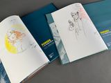 three books that are open on a table