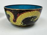 a bowl with a dragon design on it on a table