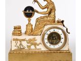 une horloge dorée et blanche représentant une femme tenant un globe terrestre
