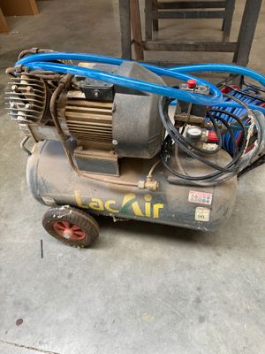 un petit compresseur d'air posé par terre à côté d'une chaise