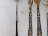 five spoons, two forks, and a spoon on a table