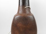 a brown and black vase with a light on it