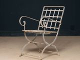 an old iron chair sitting on top of a floor next to a black wall