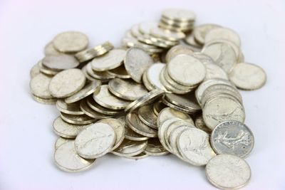 a pile of silver coins on a white surface