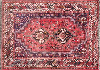 an antique persian rug with red and blue colors