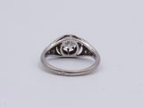 a close up of a diamond ring on a white surface