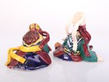 two figurines of a man and a woman sitting on a rock