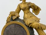a statue of a woman sitting on top of a clock
