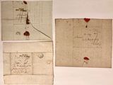 trois vieux morceaux de papier sur lesquels sont inscrits des mots, posés sur une table