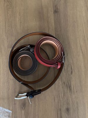deux ceintures posées sur un parquet