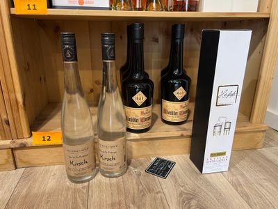 trois bouteilles de vin sur une étagère à côté d'une télécommande