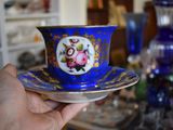 a person holding a cup and saucer in their hand