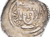 a close up of a silver coin with a face on it