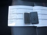 two cell phones sitting on top of a paper on a car seat