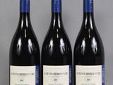 trois bouteilles de vin sont alignées sur une table