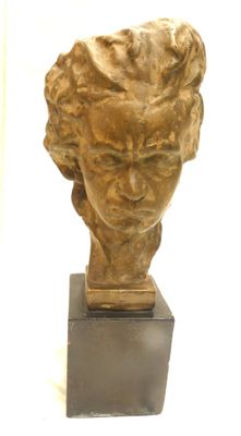 statue représentant la tête d'une femme, posée sur un socle en bois