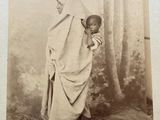 an old black and white photo of a child wrapped up in a blanket