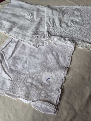 two pieces of white clothing on a bed with a white blanket