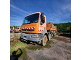 an orange truck is parked in a lot with other trucks in the background