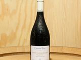 une bouteille de vin posée sur un tonneau