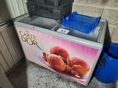 une glacière avec des glaces dessus, à côté d'une corbeille de fruits