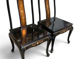 pair of black and gold painted chairs sitting on top of each other