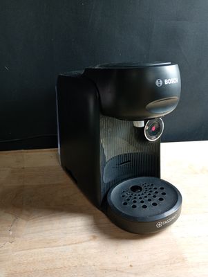 une cafetière noire posée sur une table en bois