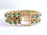 a close up of a gold bracelet with turquoise beads on it