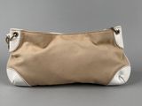a beige and white purse sitting on top of a gray surface