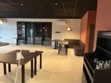 a room with tables and chairs in it with a laptop on the table