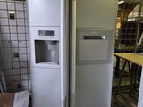 two refrigerators and a freezer in a warehouse
