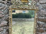 un miroir accroché à un mur de pierre, avec un mur de pierre derrière lui