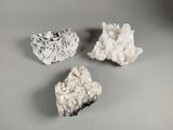 trois types de roches différents posés sur une table avec un fond gris