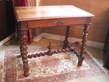 a small table with a wooden top on a rug in a room