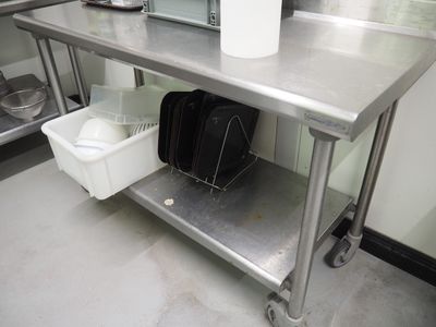 une table en métal sur laquelle est posé un sac, dans une cuisine