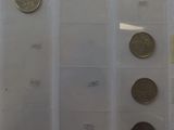 five different types of coins on display in a glass case