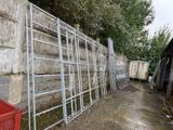 a metal fence that is leaning against a concrete wall
