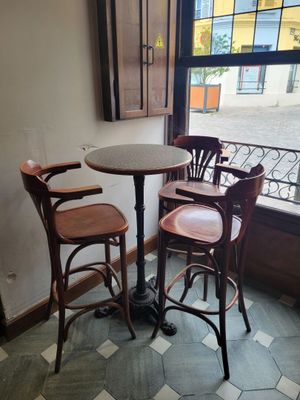 une petite table et deux chaises devant une fenêtre