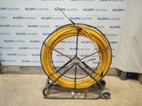 a large yellow hose sitting on a stand in front of a wall