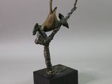 a statue of a bird perched on a branch of a tree