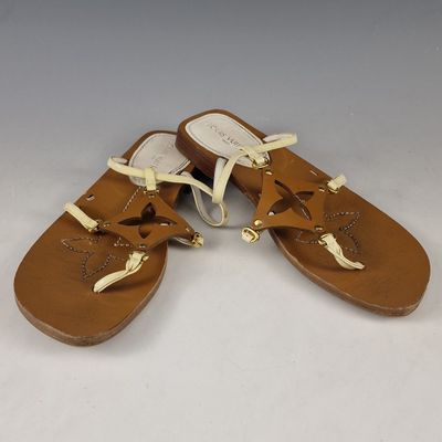 sandales en cuir beige avec des lacets blancs et un nœud sur la pointe