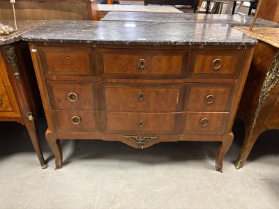 une commode au plateau en marbre, placée au milieu d'une pièce