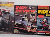 three books of indy car racing on a white surface