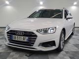 L'Audi blanche est garée dans une grande pièce au sol carrelé en damier.