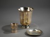 une coupe en argent et une assiette en argent posées sur une table